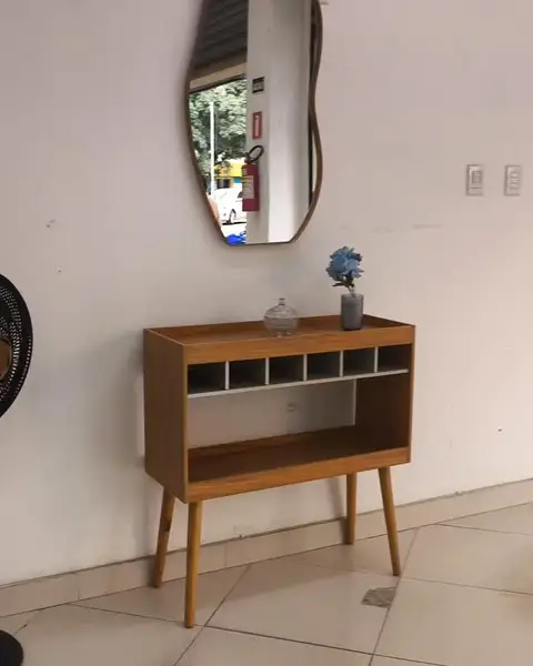 Aparador de madeira com espelho orgânico na parede